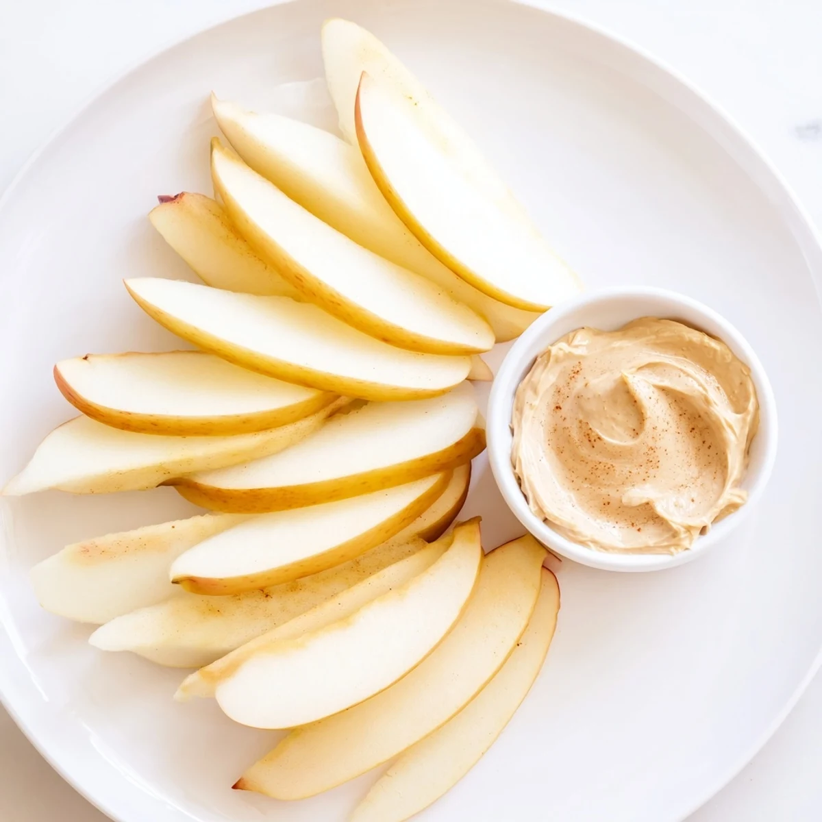 Crisp apple slices alongside creamy peanut butter dip, a wholesome snacking option.