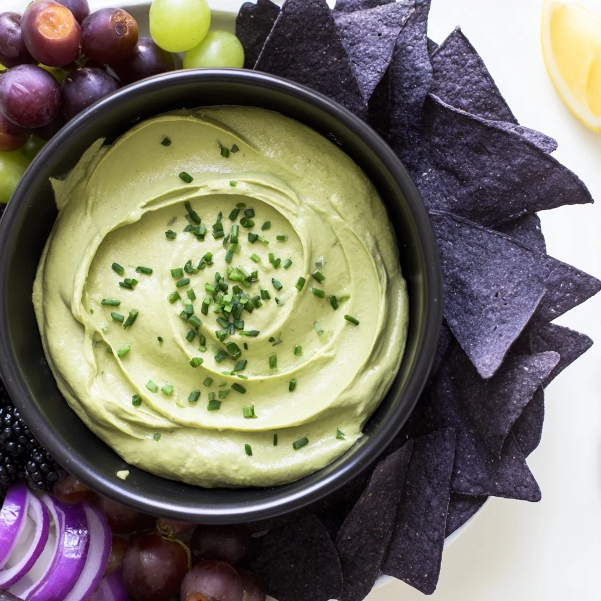 A close-up of a bubbling Witch's Brew Cauldron dip with colorful, fresh toppings for easy Halloween entertaining.