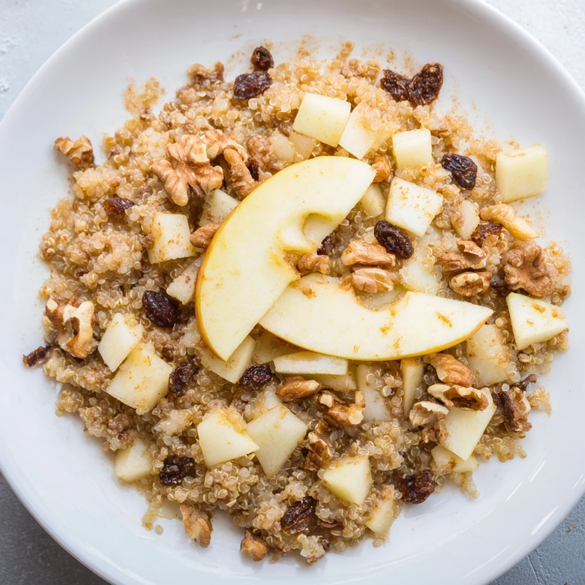 A close-up of a warm Apple Cinnamon Quinoa Bowl, inviting with cinnamon and sweet apple pieces.