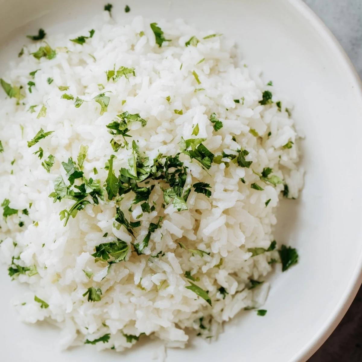 Fluffy Cilantro Lime Rice, pictured with a bright green hue, looks perfect served alongside grilled chicken.