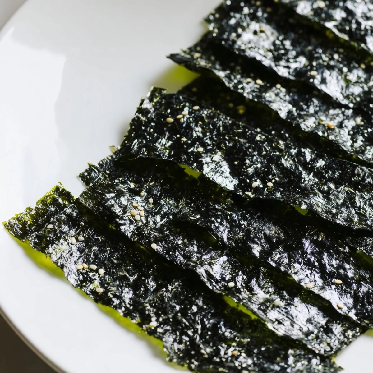 Golden-brown roasted seaweed chips glisten with sesame oil and fine sea salt, ready to snack.  