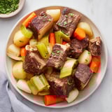 Steaming Authentic Pot-au-Feu with crusty bread and cornichons, a classic French stew.