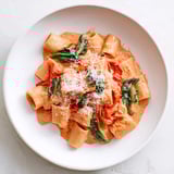 Creamy Lightened-Up Vodka Rosé Christmas Pasta, vibrant green spinach complements the rich tomato vodka sauce.