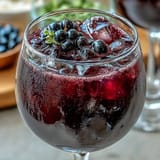 Two elegant glasses of Black Currant and Cassis Cocktail ready to serve at a French-inspired dinner party.