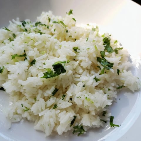 Steaming Cilantro Lime Rice: Fluffy, vibrant grains with fresh cilantro and zesty lime, ideal side dish.