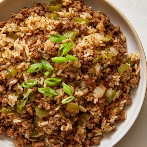 A steaming bowl of Cajun Dirty Rice, a flavorful Southern dish with ground meat and spices.