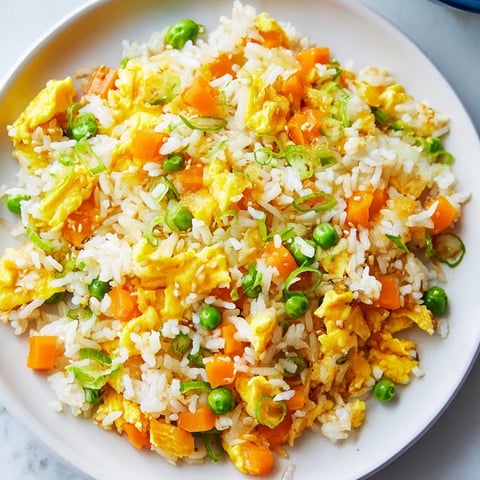 Fluffy, savory Egg Fried Rice with colorful veggies and a drizzle of sesame oil, ready to serve.