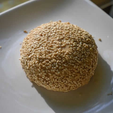 Golden-brown Palestinian Kahk cookies, filled with sweet date paste, and coated in sesame seeds.