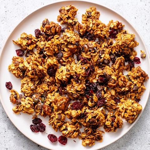 Golden-baked Granola Clusters with oats, nuts, and honey on a baking sheet.