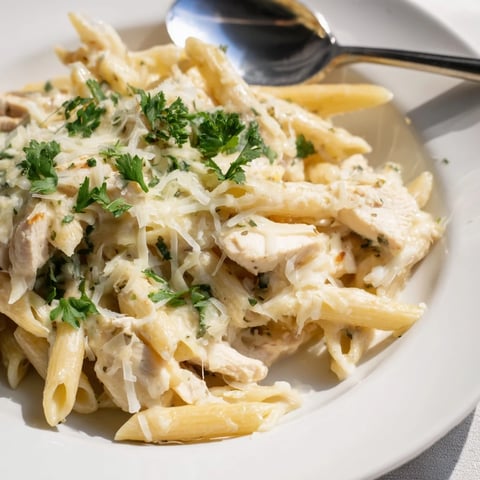 Golden-brown baked Chicken Alfredo Casserole with bubbling mozzarella, served from a rustic 9x13 dish.  