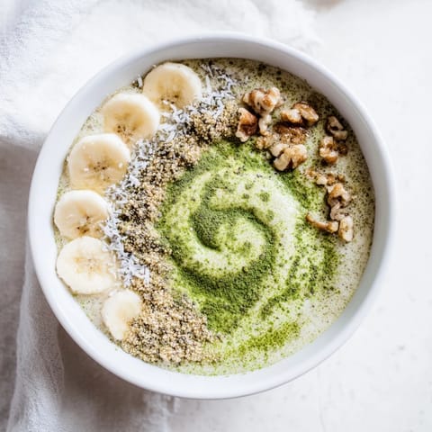 A vibrant bowl of High-Protein Eggnog Matcha Overnight Oats with a dusting of cinnamon, ready to eat.