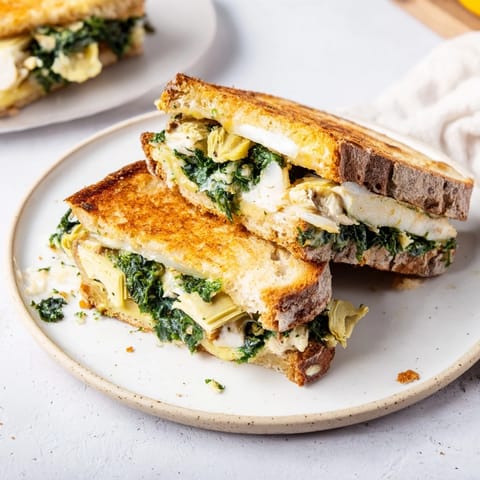 Air fryer cooked Air Fryer Spinach & Artichoke Dip grilled cheese, golden and bubbling, ready to be devoured.
