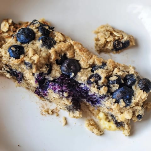 Freshly baked Blueberry Banana Oatmeal Protein Bars, described as chewy and packed with fruit and protein.