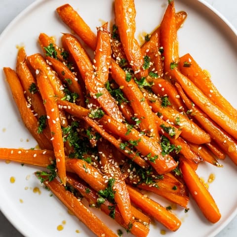 Close-up of caramelized Maple Mustard Roasted Carrots, ready to be garnished and served hot.