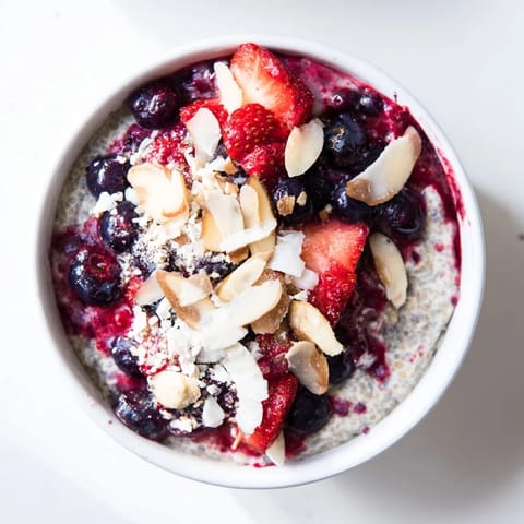 A close-up of berry chia pudding: layers of creamy chia and juicy mixed berries, beautifully arranged.