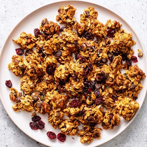Golden-baked Granola Clusters with oats, nuts, and honey on a baking sheet.