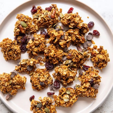 Warm Granola Clusters piled high with dried cranberries and dark chocolate chips.