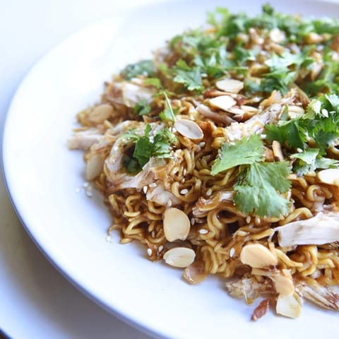 A refreshing bowl of Crunchy Ramen Chicken Salad with crisp carrots, scallions, and golden ramen noodles, ideal for a potluck.