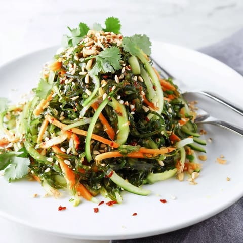 Served chilled as a refreshing vegan appetizer, this nutrient-dense Seaweed Salad is garnished with toasted sesame seeds and fresh cilantro for a savory crunch.  