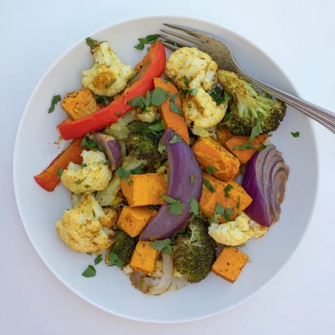 Roasted cauliflower, broccoli, and sweet potatoes coated in turmeric spices for a vibrant wellness side dish.