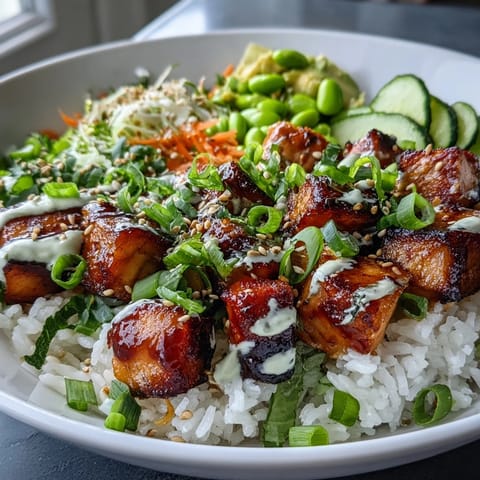 Golden-brown broiled salmon cubes rest on fluffy jasmine rice, topped with crisp cucumber, shredded carrots, and creamy avocado slices.  