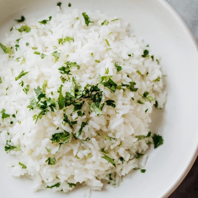 Fluffy Cilantro Lime Rice, pictured with a bright green hue, looks perfect served alongside grilled chicken.