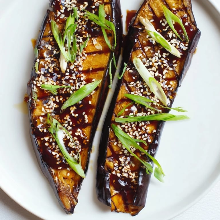 Savory miso glazed eggplant served warm with sesame garnish, ideal as a vegan side dish.