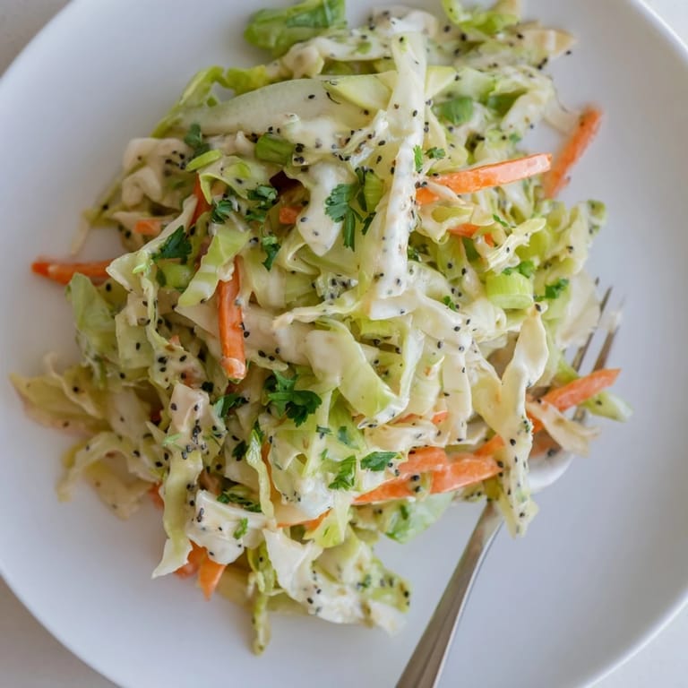 Green Cabbage and Apple Slaw served in a rustic bowl, featuring shredded carrots and a light, tangy apple cider dressing.