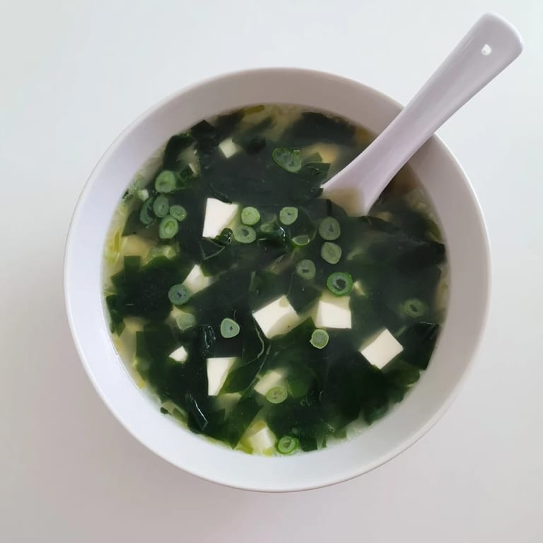 Serving suggestion for Wakame Soup, a healthy appetizer with wakame seaweed, tofu, and a delicate dashi broth in a ceramic bowl.